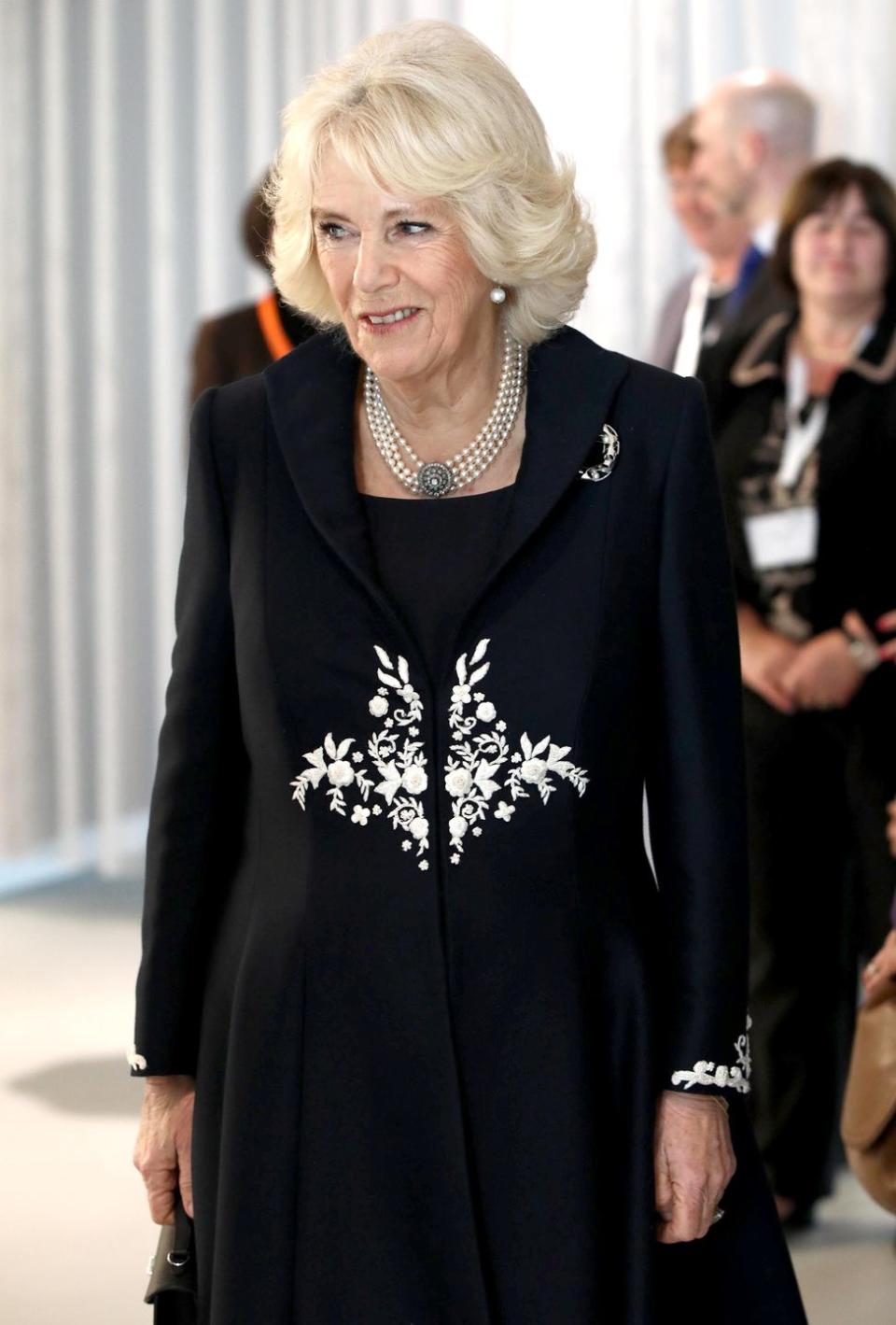 <p>Camilla wore an embroidered black coat, pearl earrings, a pearl choker, and diamond broach to attend the launch of the Royal Osteoporosis Society. </p>