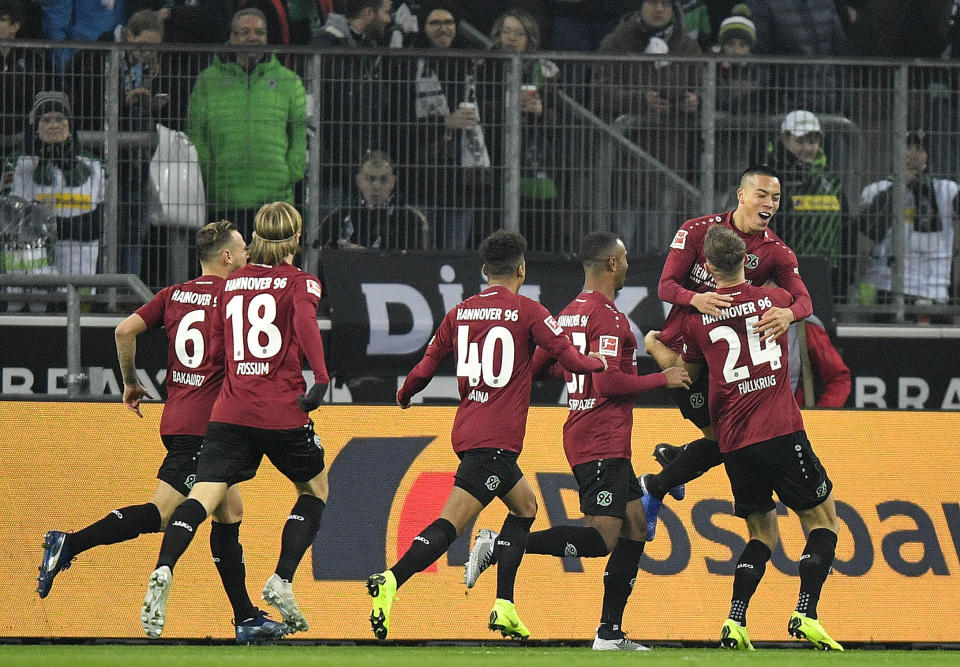 Hannover's Bobby Wood, right up, celebrates after scoring the opening goal in the first minute during the German Bundesliga soccer match between Borussia Moenchengladbach and Hannover 96 at the Borussia Park in Moenchengladbach, Germany, Sunday, Nov. 25, 2018. (AP Photo/Martin Meissner)