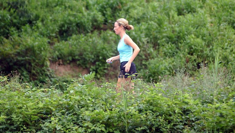 A woman runs on a trail with overgrown plants in Washington Crossing State Park, Titusville, N.J. Wednesday, Aug. 10, 2005. The Asthma and Allergy Foundation of America ranked the best, and worst, U.S. cities for seasonal allergies in 2023.