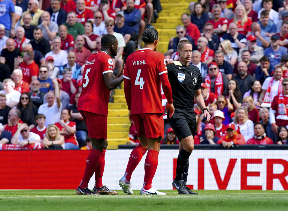 Liverpool's Ibrahima Konate, left is shown a yellow card by referee John Brooks after fouling Aston Villa's Ollie Watkins, during the English Premier League soccer match between Liverpool and Aston Villa, at Anfield stadium, Liverpool, England, Saturday May 20, 2023. (Peter Byrne/PA via AP)