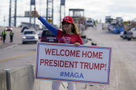 A supporter of President Donald Trump waits for the motorcade on the road to Mar-a-Lago, Trump's Palm Beach estate, on Wednesday, Jan. 20, 2021, in West Palm Beach, Fla. (AP Photo/Lynne Sladky)