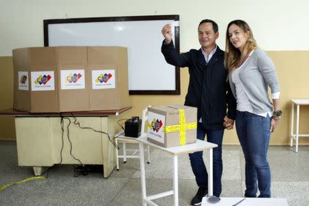 Governor of Tachira state Jose Gregorio Vielma casts his vote accompanied by his wife Karla Jimenez during a nationwide election for new governors in San Cristobal, Venezuela, October 15, 2017. REUTERS/Carlos Eduardo Ramirez