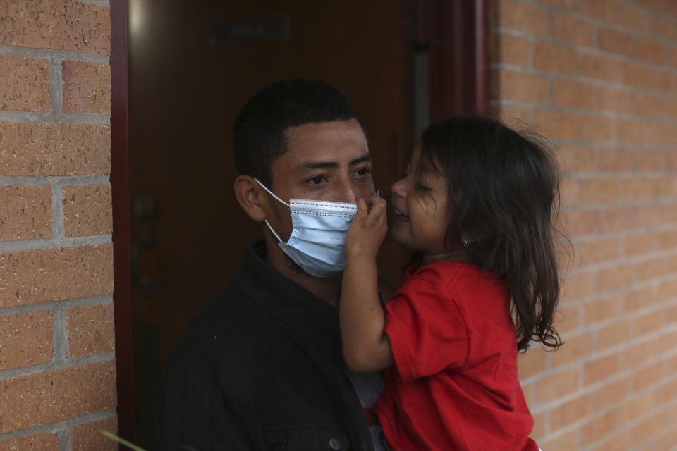 A migrant and his daughter wait for transportation to the airport, at Our Lady of Guadalupe Catholic Church in McAllen, Texas, on Palm Sunday, March 28, 2021. U.S. authorities are releasing migrant families at the border without notices to appear in immigration court, and sometimes without any paperwork at all. A spokesman for the National Border Patrol Council, a union that represents Border Patrol agents, said it was done to cut processing time at overwhelmed holding facilities. He said it takes an hour to 90 minutes to prepare one notice to appear in court. (AP Photo/Dario Lopez-Mills)