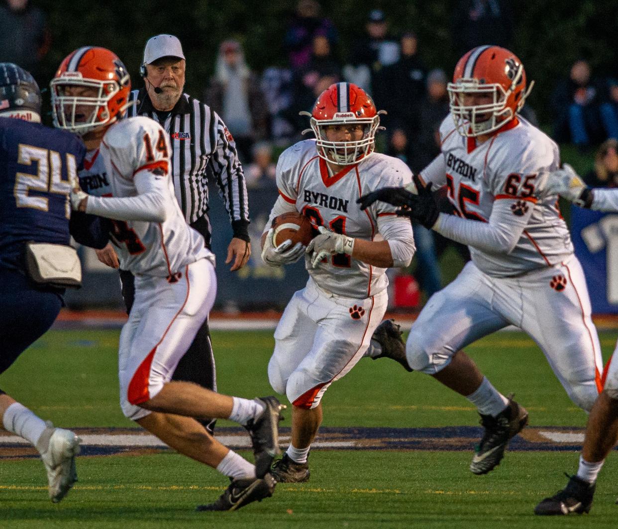 Byron's Chandler Binkley finds a hole in the IC Catholic defense with blocking from Ethan Palzkill, left, and Jared Claunch in the second quarter of the Class 3A state semifinal game in Elmhurst on Saturday, Nov. 20, 2021.