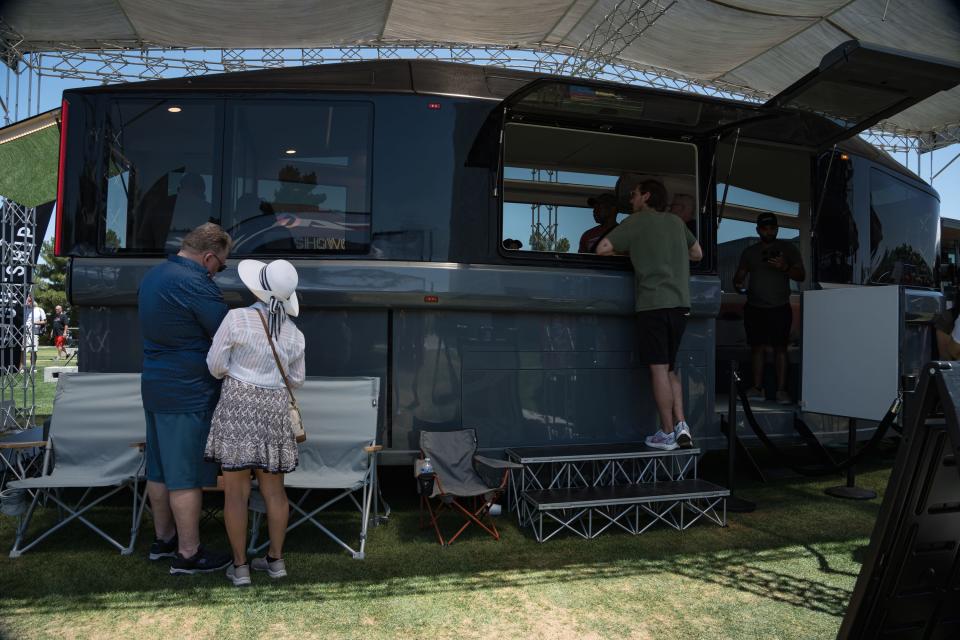 People gather around a model of the Lightship L1 electric travel trailer at the Electrify Expo outside State Farm Stadium on May 4, 2024 in Glendale, Ariz.