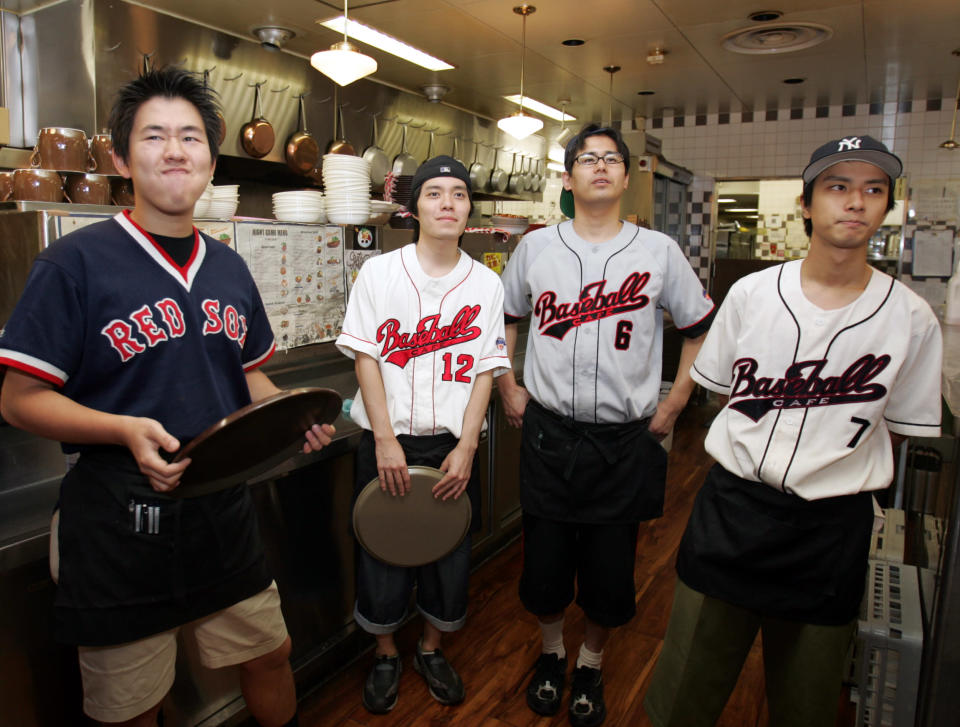 Employees at a baseball theme restaurant in Tokyo watch the television broadcast of Seattle Mariners outfielder Ichiro Suzuki's game in Oakland, California September 30, 2004. REUTERS/Yuriko Nakao