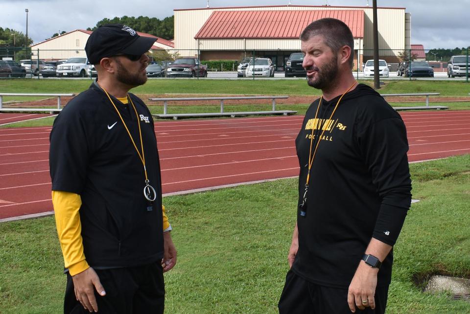 Richmond Hill head football coach Matt LeZotte, right, and assistant head coach Patrick Means in a discussion during a recent practice.