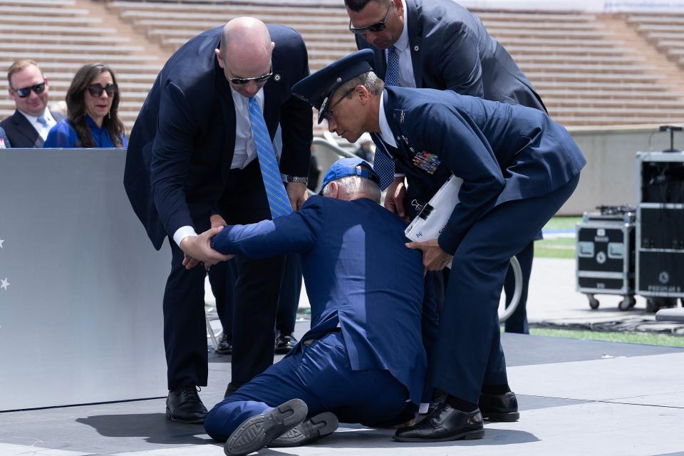 TOPSHOT - US President Joe Biden is helped up after falling during the graduation ceremony at the United States Air Force Academy, just north of Colorado Springs in El Paso County, Colorado, on June 1, 2023. (Photo by Brendan Smialowski / AFP) (Photo by BRENDAN SMIALOWSKI/AFP via Getty Images)