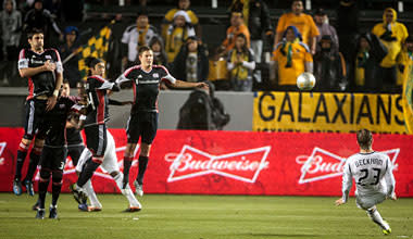 David Beckham (R) slips and falls during a first-half free kick. He spent the second half sitting on the bench