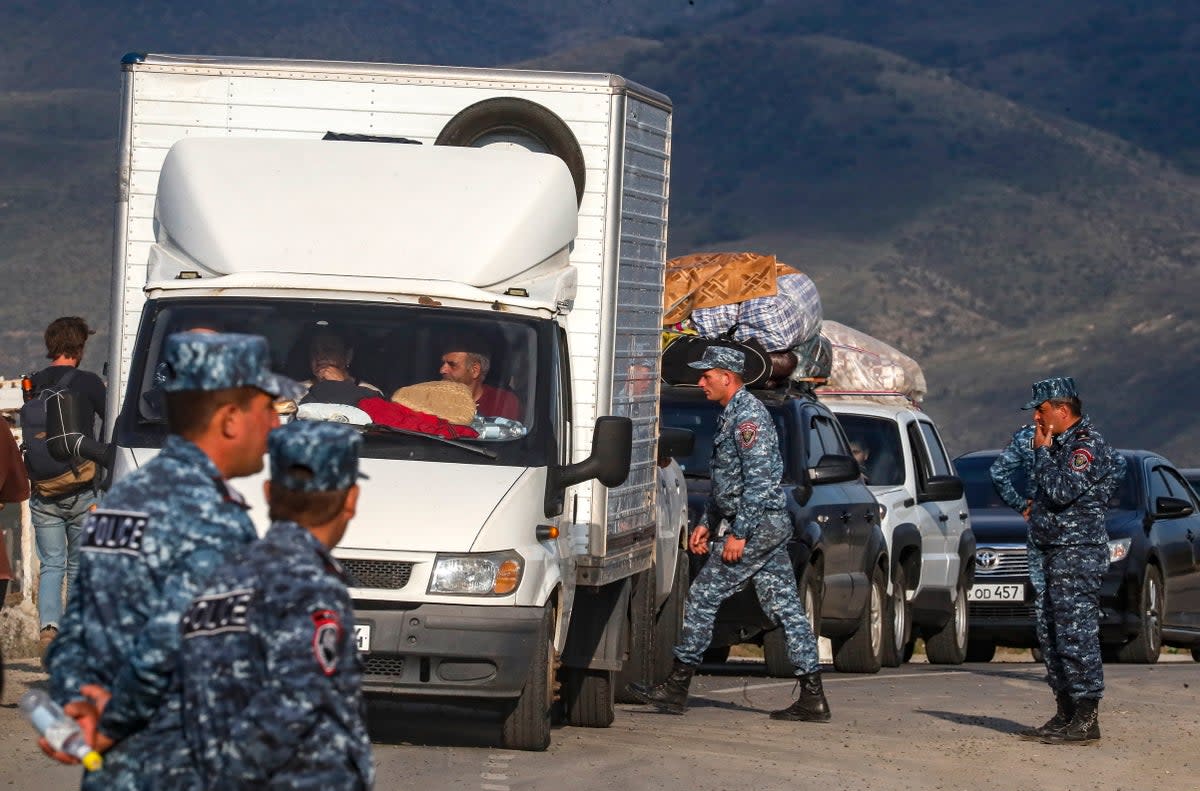 Armenian police organise passing of ethnic Armenians fleeing Nagorno-Karabakh region after they crossed the Azerbaijan-Armenia border near the village of Kornidzo (EPA)