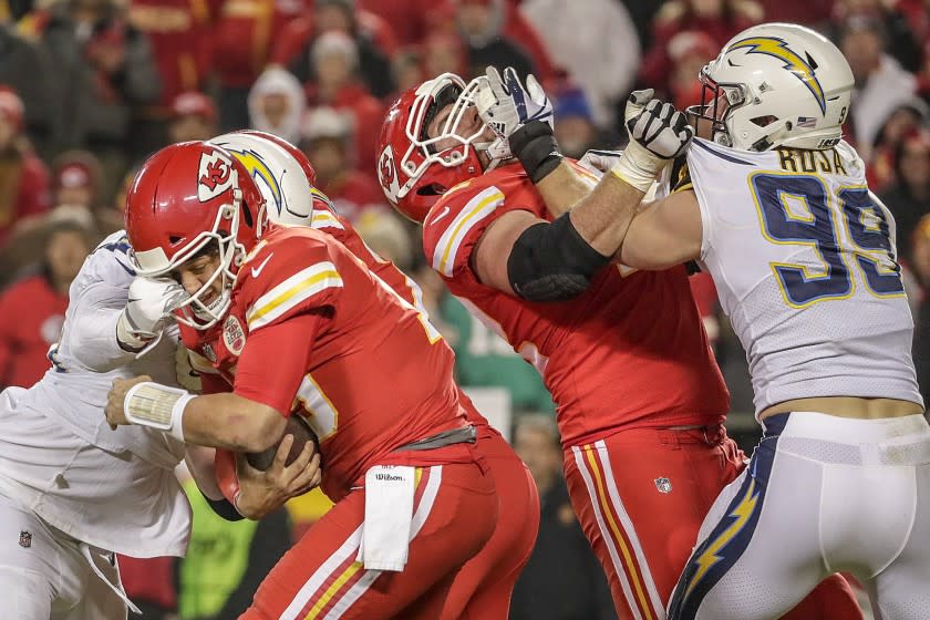 Chargers linebacker Melvin Ingram sacks Chiefs quarterback Patrick Mahomes as defensive lineman Joey Bosa wrestles with offensive lineman Eric Fisher.