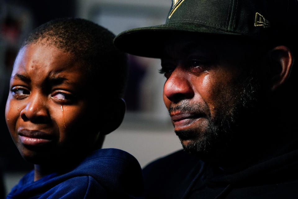 Wayne Jones, holds his son Donell, while speaking during an interview with The Associated Press about his mother Celestine Chaney, who was killed in Saturday's shooting at a supermarket, in Buffalo, N.Y., Monday, May 16, 2022. (AP Photo/Matt Rourke)