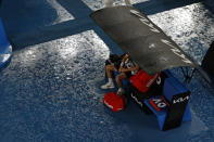 Stefanos Tsitsipas of Greece waits for a rain to clear during his quarterfinal against Jannik Sinner of Italy at the Australian Open tennis championships in Melbourne, Australia, Wednesday, Jan. 26, 2022. (AP Photo/Tertius Pickard)