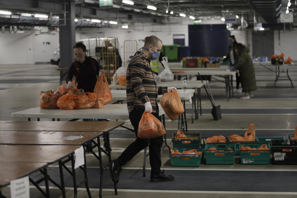 Volunteers for the Edible London food project sort donated food and essential items, to be delivered to vulnerable residents in the Harringey Council, at a hub setup as a result of Coronavirus inside the Tottenham Hotspur Stadium, in north London, Wednesday, April 1, 2020. Many elderly and vulnerable people have difficulty to get shopping with reduced bus and train services due the government asking only essential workers travel during this Covid-19 lockdown to stop its spread. The new coronavirus causes mild or moderate symptoms for most people, but for some, especially older adults and people with existing health problems, it can cause more severe illness or death.(AP Photo/Matt Dunham)
