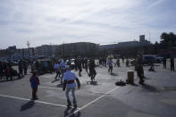 Perfomers from POOR Magazine and Deecolonize Academy dance in a parking lot, the only undeveloped portion of the shellmound in West Berkeley where ancestors of today's Ohlone people established the first human settlement on the shores of the San Francisco Bay, in Berkeley, Calif., Wednesday, March 13, 2024. Berkeley's City Council voted unanimously Tuesday, March 12, 2024, to adopt an ordinance giving the title of the land to the Sogorea Te' Land Trust, a women-led, San Francisco Bay Area collective that works to return land to Indigenous people and that raised the funds needed to reach the agreement. (AP Photo/Jeff Chiu)