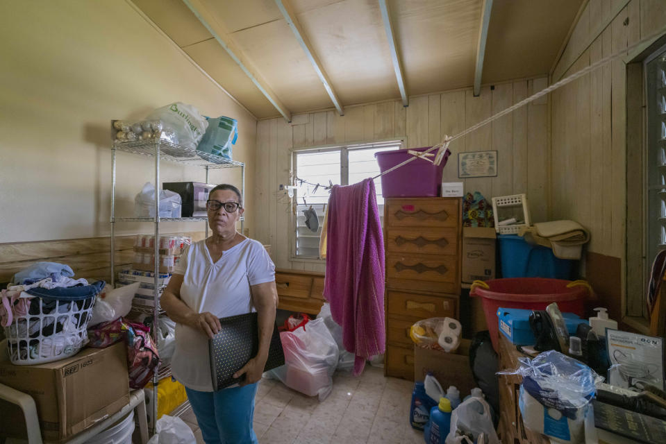 Virmisa Rivera poses for a photo in her home that was damaged by Hurricane Maria nearly five years ago, in Loiza, Puerto Rico, Thursday, Sept. 15, 2022. She said FEMA gave her money to rent a house while they repaired her roof, but no crews came by. Her boyfriend attempted to install zinc panels, but they don’t protect from heavy rain. (AP Photo/Alejandro Granadillo)