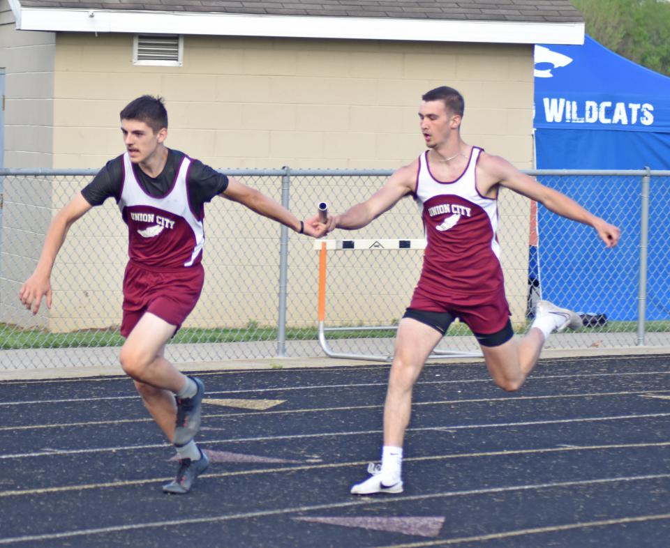 Union City's Nathaniel Maurer hands off to teammate Owen Kincaid during the 800 meter relay on Friday
