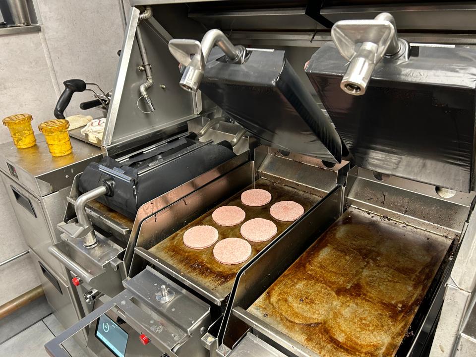 Uncooked burger patties on a McDonald's grill