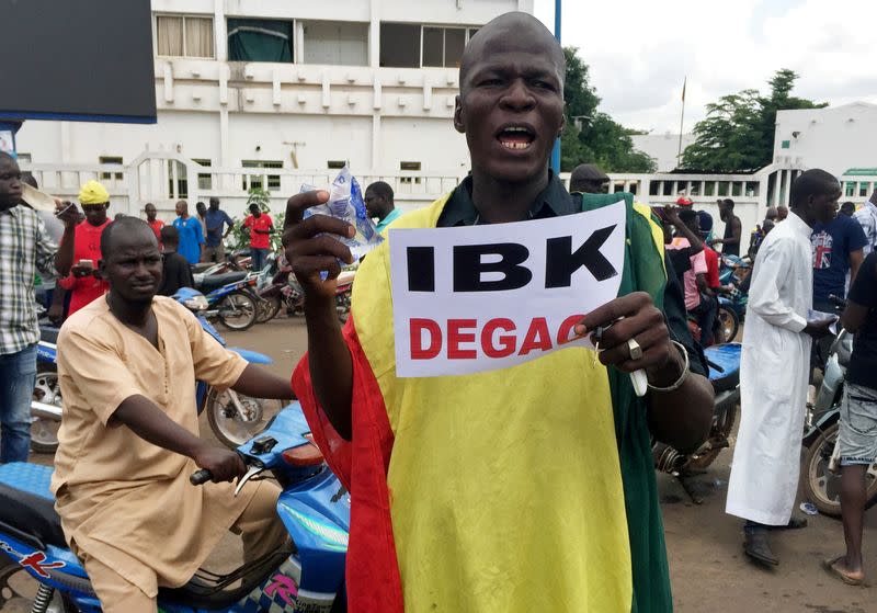 Opposition supporters react to the news of possible military mutiny, at Independence Square in Bamako