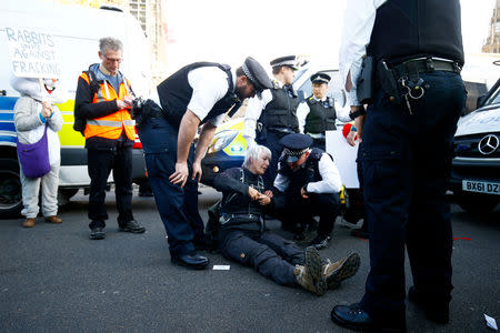 Police officers move a protester from the road outside the Houses of Parliament during a demonstration against fracking, in London, Britain, October 31, 2018. REUTERS/Henry Nicholls