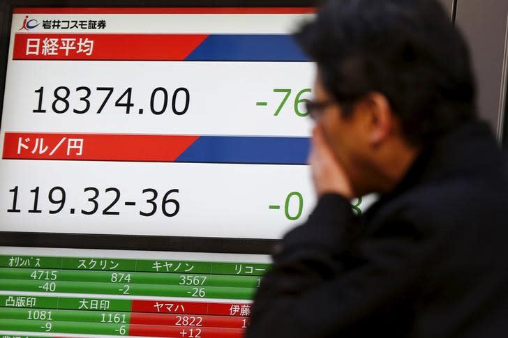 A man looks at a screen displaying the exchange rates between the Japanese yen and the U.S. dollar (bottom) outside a brokerage in Tokyo, Japan January 5, 2016. REUTERS/Thomas Peter