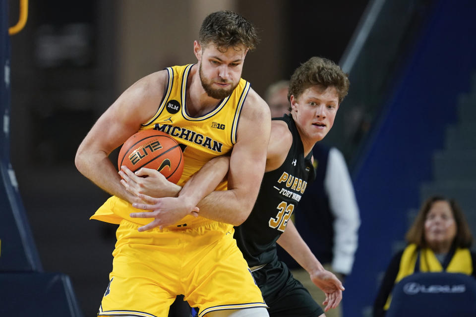 Michigan center Hunter Dickinson (1) battles for a rebound with Purdue Fort Wayne guard Eric Mulder (32) in the second half of an NCAA college basketball game in Ann Arbor, Mich., Monday, Nov. 7, 2022. (AP Photo/Paul Sancya)