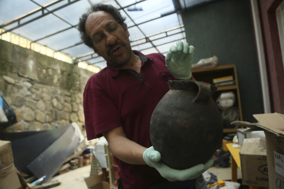 Jedu Sadarnaga shows pottery on Thursday, Nov. 15, 2018 from one of the tombs found at a Bolivian quarry near the capital of La Paz. The tombs contained remains belonging to more than 100 individuals and were buried with more than 30 vessels used by the Incas. (AP Photo/Luis Gandarillas)