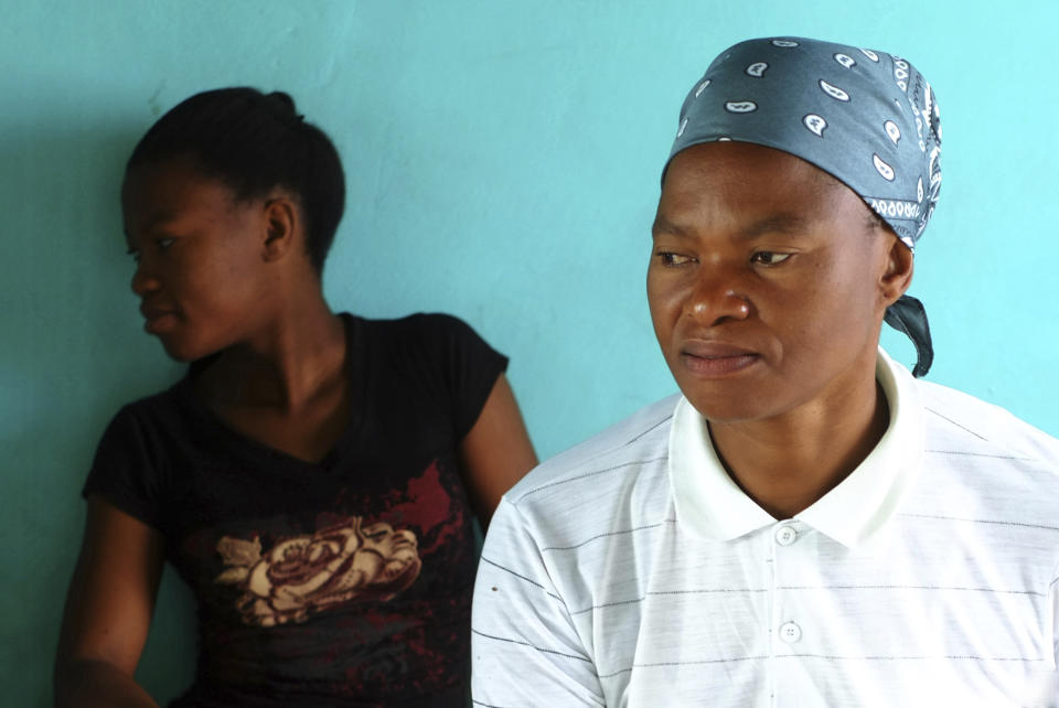 Matefo Litali, 53, a Lesotho garment worker, and her 20-year-old daughter, Refiloe, sit together in their shared room in the town of Ha Thetsane, Maseru, Lesotho, on Friday, Dec. 11, 2020. At the beginning of the pandemic in March, Matefo was one of thousands garment workers around the world affected by the sudden closing of factories such as Tzicc Clothing, which makes apparel for U.S-based giants J.C. Penney and Walmart. Not only did the impact of the layoffs affect her finances but also took a great toll on her mental health. (Neo Ntsoma/The Fuller Project via AP)