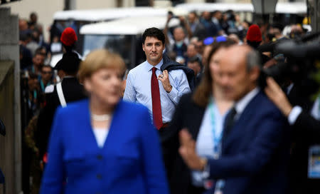 Canadian Prime Minister Justin Trudeau arrives, with Germany's Chancellor Merkel foreground, at the G7 summit in Taormina, Sicily Italy, May 26, 2017. REUTERS/Dylan Martinez