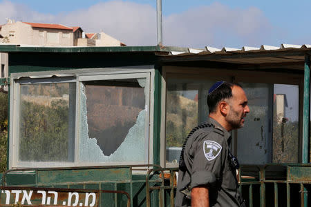 An Israeli border policeman walks past a damaged security booth near the scene where a police spokeswoman said a Palestinian gunman killed three Israelis guards and wounded a fourth in an attack on a Jewish settlement in the occupied West Bank before himself being shot dead, September 26, 2017. REUTERS/Ammar Awad