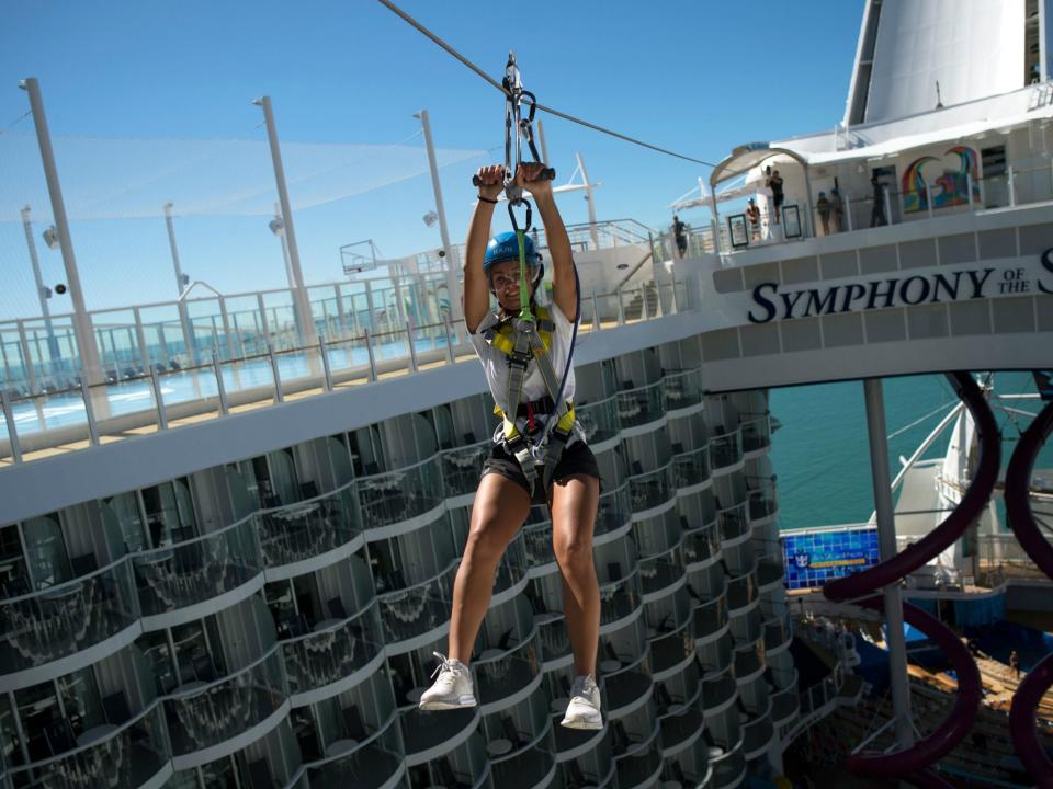 A woman slides down a zip-line aboard a Royal Caribbean's cruise ship. A man died after colliding with his wife on a zip line in Honduras while on their honeymoon: JORGE GUERRERO/AFP/Getty Images