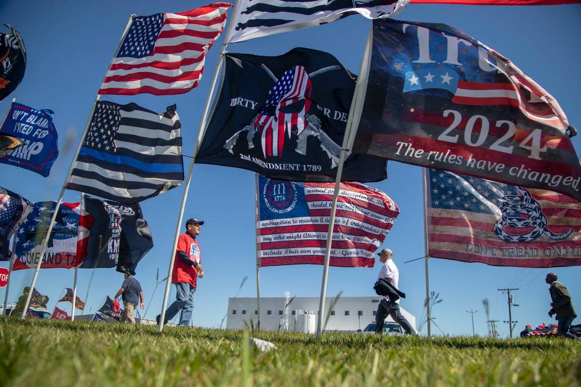 Flags blow in a stiff wind prior to a GOP rally featuring former president Donald Trump, at Wilmington International Airport Friday, Sept. 23, 2022.