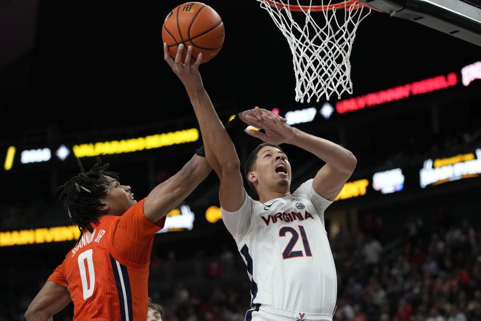 Illinois' Terrence Shannon Jr. (0) fouls Virginia's Kadin Shedrick (21) during the second half of an NCAA college basketball game Sunday, Nov. 20, 2022, in Las Vegas. (AP Photo/John Locher)