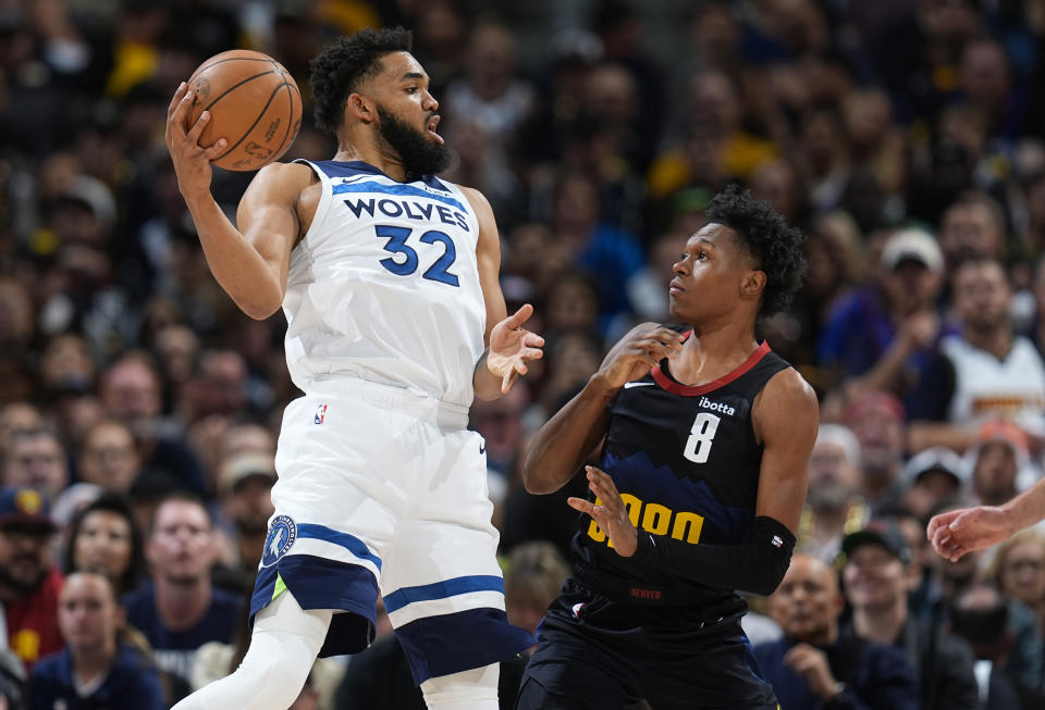 Minnesota Timberwolves center Karl-Anthony Towns, left, fields a pass next to Denver Nuggets forward Peyton Watson during the first half of Game 5 of an NBA basketball second-round playoff series Tuesday, May 14, 2024, in Denver (AP Photo/David Zalubowski)