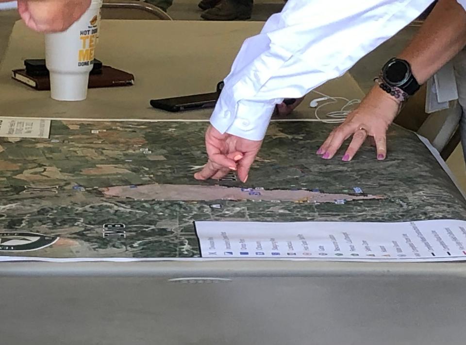 Staff members of the Texas Division of Emergency Management overlook a newly printed map of the area affected by the Mesquite Heat Fire Friday after a briefing at the View Volunteer Fire Department.