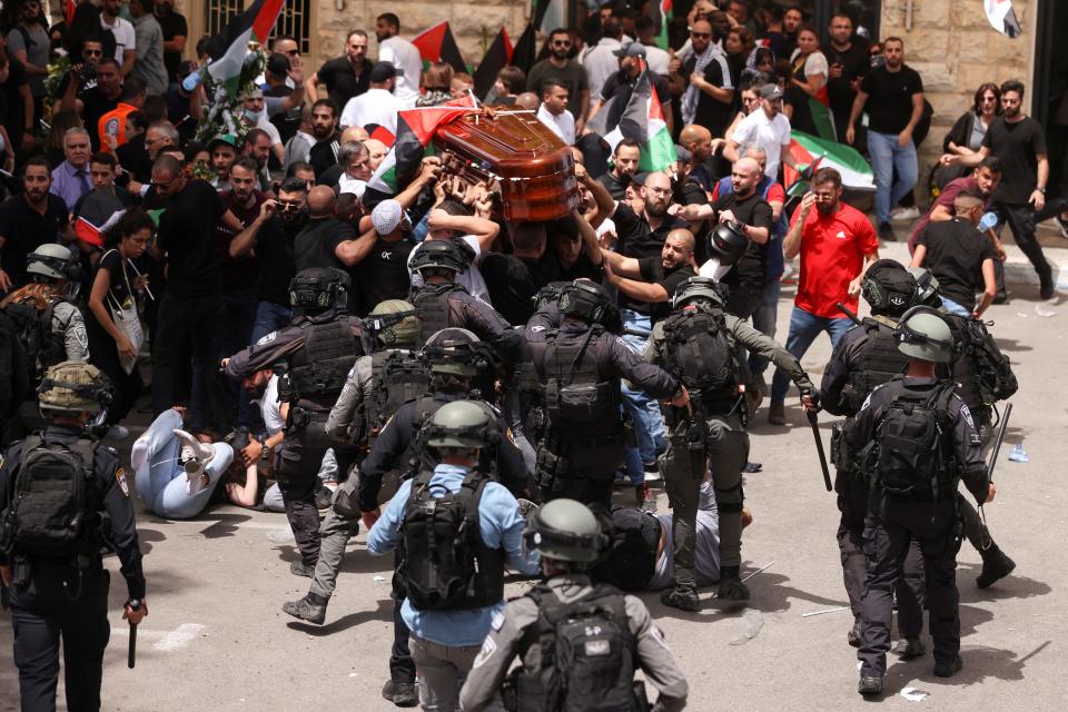 Family and friends carry the coffin of Al Jazeera reporter Shireen Abu Akleh, who was killed during an Israeli raid in Jenin in the occupied West Bank, as clashes erupted with Israeli security forces, during her funeral in Jerusalem, May 13, 2022.