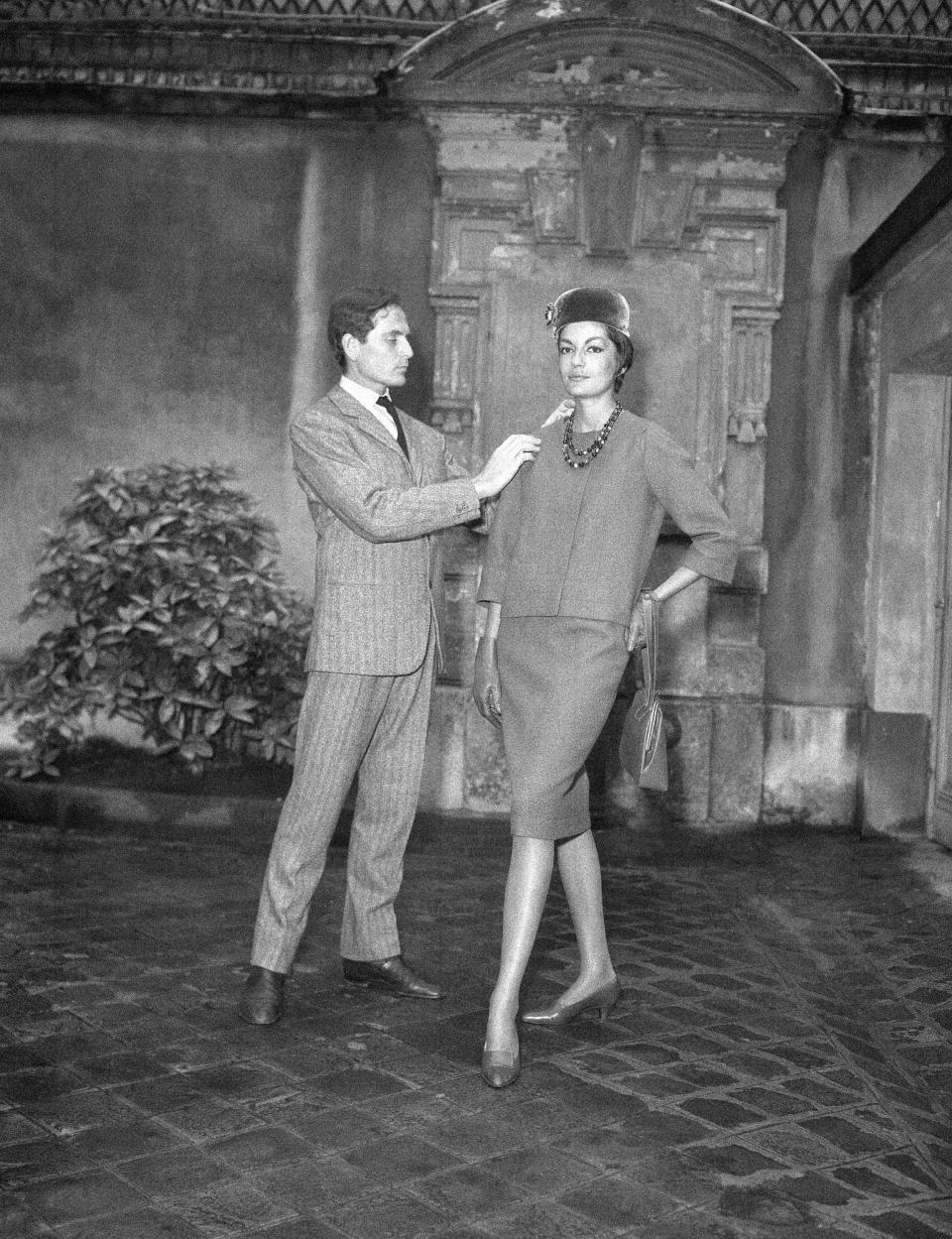 FILE - In this Sept.13, 1960 file photo, Parisian designer Pierre Cardin, with one of his models, shows the new uniform he has created for the hostesses of French television in Paris. France's Academy of Fine Arts says famed fashion designer Pierre Cardin has died at 98 (AP Photo/Pierre Godot, File)