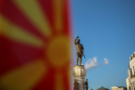 FILE PHOTO: A Macedonian flag is pictured in front of the "warrior monument" in central Skopje, Macedonia, May 31, 2018. REUTERS/Marko Djurica/File Photo