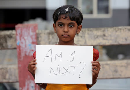 A gild holds a placard during a protest against the rape of an eight-year-old girl in Kathua, near Jammu, in Kochi, India April 15, 2018. REUTERS/Sivaram V