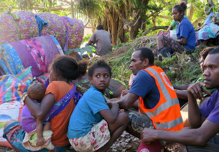 Residents sit with their possessions as they prepare to board a boat at Lolowai Port as they evacuate due to the Manaro Voui volcano continuing to emanate smoke and ash on Vanuatu's northern island of Ambae in the South Pacific, October 1, 2017. REUTERS/Ben Bohane