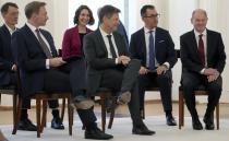 From left, German Health Minister Karl Lauterbach, German Finance Minister Christian Lindner, German Minister for Family Affairs, Senior Citizens, Women and Youth, Anne Spiegel, German Economy and Climate Minister Robert Habeck, German Agriculture Minister Cem Ozdemir and German Chancellor Olaf Scholz, are seated as they attend a reception after receiving their letters of appointment by German President Frank-Walter Steinmeier at Bellevue Palace in Berlin, Germany, Wednesday, Dec. 8, 2021. Scholz has become Germany's ninth post-World War II chancellor, opening a new era for the European Union's most populous nation and largest economy after Angela Merkel's 16-year tenure. Scholz's government takes office with high hopes of modernizing. (AP Photo/Michael Sohn)