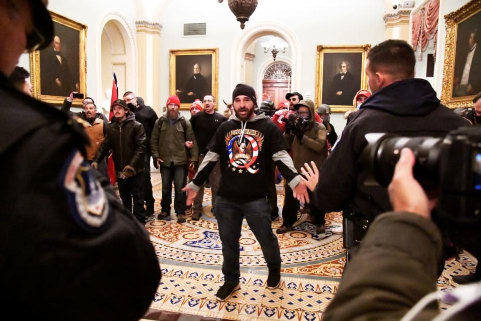 <div class="inline-image__title">USA-ELECTION/</div> <div class="inline-image__caption"><p>Douglas Austen Jensen of Iowa, a supporter of President Donald Trump wearing a QAnon shirt, confronts police as Trump supporters demonstrate on the second floor of the U.S. Capitol near the entrance to the Senate after breaching security defenses, in Washington, U.S., January 6, 2021. </p></div> <div class="inline-image__credit">Mike Theiler/Reuters</div>