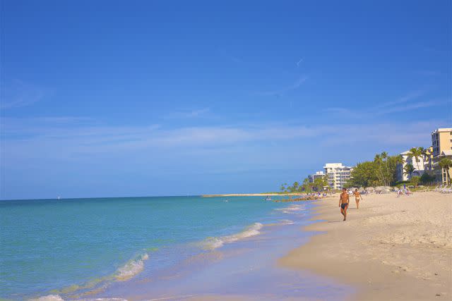 Barry Winiker / Getty Images People walking on beach at Lowdermilk Park, Naples, FL