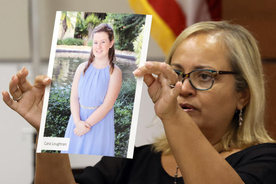 FILE - Family friend Isabel Dalu holds a photograph of Cara Loughran before giving a victim impact statement on behalf of the Loughran family during the penalty phase of the trial of Marjory Stoneman Douglas High School shooter Nikolas Cruz at the Broward County Courthouse in Fort Lauderdale, Fla., Wednesday, Aug. 3, 2022. Cara Loughran was killed in the 2018 shootings. (Amy Beth Bennett/South Florida Sun Sentinel via AP, Pool, File)