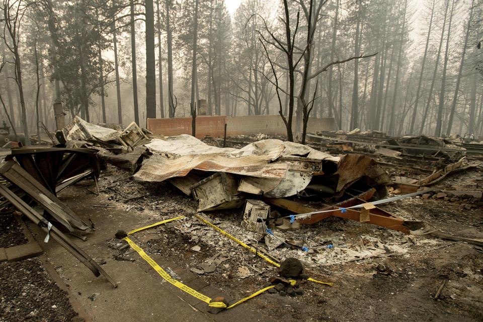 FILE - In this Wednesday, Nov. 14, 2018 file photo, tape marks a spot where sheriff's deputies recovered the body of a Camp Fire victim in Paradise, Calif. The body count from California's deadliest wildfire is back down to 85 after authorities determined that a bone fragment previously classified as "unidentified" belongs to a victim named back in January. The Butte County Sheriff's office said Wednesday, Sept. 25 2019 that the number of unidentified victims from the November 2018 Camp Fire now stands at one (AP Photo/Noah Berger, File)