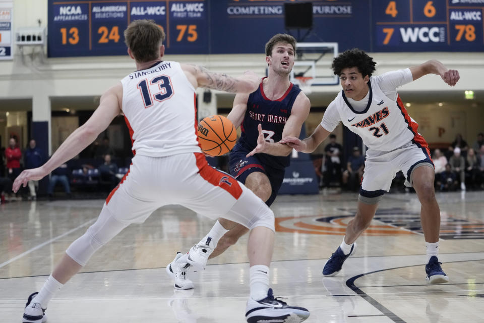 Saint Mary's guard Augustas Marciulionis, center, drives against Pepperdine guards Cord Stansberry, left, and Nils Cooper during the first half of an NCAA college basketball game Thursday, Feb. 29, 2024, in Malibu, Calif. (AP Photo/Ryan Sun)