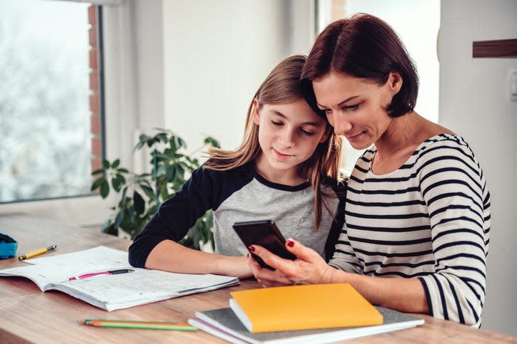 Mother using smart phone with daughter