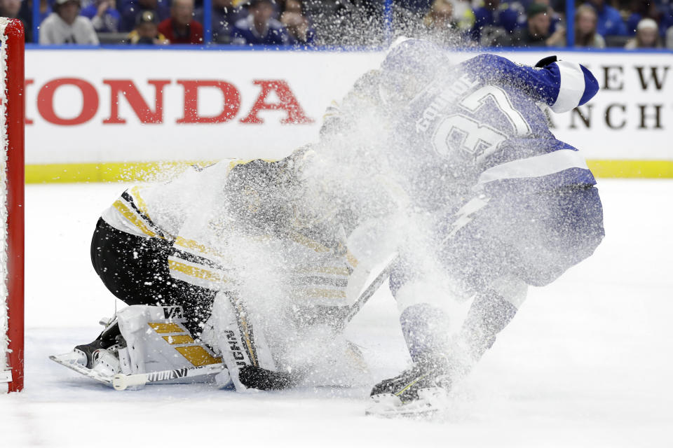 Boston Bruins goaltender Tuukka Rask (40) gets covered in ice by Tampa Bay Lightning center Yanni Gourde (37) during the second period of an NHL hockey game Tuesday, March 3, 2020, in Tampa, Fla. (AP Photo/Chris O'Meara)