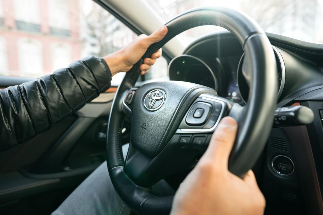 Man driving Toyota car. Close up of steering wheel with driver hands. Lisbon, Portugal. 07.01.2021. High quality photo