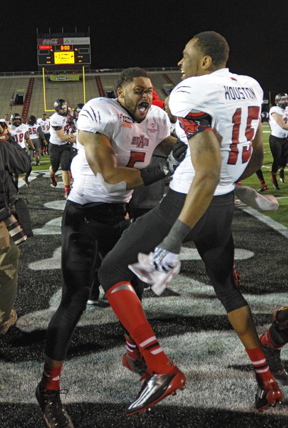 Arkansas State players Kyle Coleman (5) and Tres Houston (15) celebrate their teams victory over Ball State 23-20 in the GoDaddy Bowl NCAA college football game in Mobile, Ala., Sunday, Jan. 5, 2014. (AP Photo/G.M. Andrews)